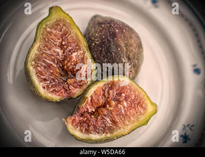 Eine Nahaufnahme von drei Feigen auf einer Platte Stockfoto