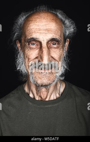 - Porträt von Happy älterer Mann mit grauen Haaren, Bart und Schnurrbart in die Kamera posieren. Schließen isolierte schwarze Hintergrund. Studio erschossen. Glück, fühlen Stockfoto