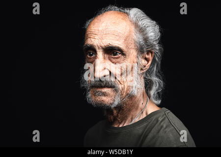 Traurig müde alte Mann mit vielen Falten in seinem Gesicht warten auf den Tod. aus der Nähe Seitenansicht Foto. Isolierte schwarze Hintergrund. Studio geschossen. Kopieren Sie Platz Stockfoto