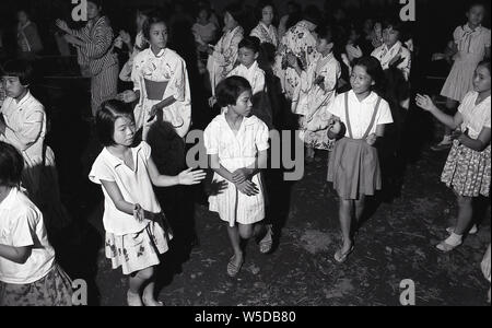 [1950er Jahre Japan - japanische Kinder Kinder an religiösen Festival] - Kinder in Yukata beim Bon-odori-Tanz in Kobe, Hyogo Präfektur, 1959 (Showa 34). Die Buddhistischen Einhaltung der Obon (お盆) ehrt die Geister der Vorfahren. Stockfoto