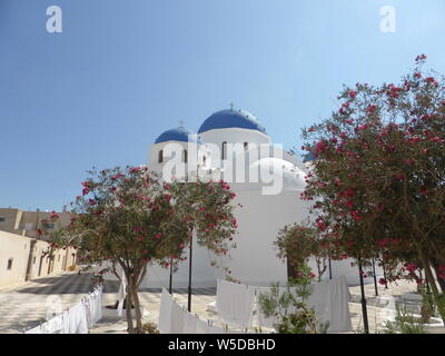 Ikonischen Blauen und Weißen Kuppelkirche und Garten in Santorini Stockfoto