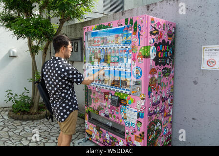 Eine asiatische Touristen kaufen ein Getränk von einer bunten Automaten, Omotesando, Tokio, Japan, 20192019 Stockfoto