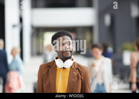 Inhalt verträumt moderne Afro Kerl mit Kopfhörern Kreuzung voll lobby und Planung Ferienhäuser Stockfoto