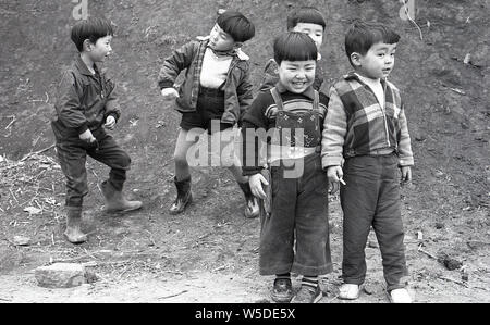 [1960s Japan - Japanische Jungen spielen] - fünf jungen japanischen Jungen spielen in Tengenji, Tokio, 1960 (Showa 35). Man hat einen Holster mit einer Spielzeugpistole. Stockfoto