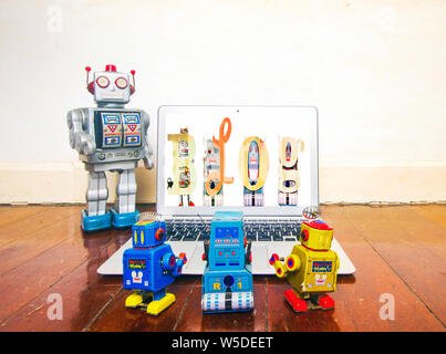 Große silberne Roboter lehrt über Blogs auf einem Laptop Stockfoto