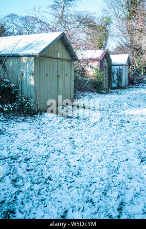 Drei alte hölzerne Schnee Garagen, mit Bäumen im Hintergrund, in der Nähe der Consett, County Durham, England, Großbritannien Stockfoto