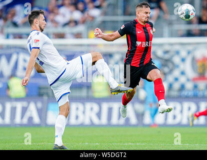 28 Juli 2019, Hessen, Wiesbaden: Fussball: 2. Bundesliga, SV Wehen Wiesbaden - Karlsruher SC, 1. Spieltag, in der BRITA-Arena. Der Karlsruher Lukas Fröde (l) und der Wiesbadener Sebastian Mrowca Kampf um den Ball. Foto: Uwe Anspach/dpa - WICHTIGER HINWEIS: In Übereinstimmung mit den Anforderungen der DFL Deutsche Fußball Liga oder der DFB Deutscher Fußball-Bund ist es untersagt, zu verwenden oder verwendet Fotos im Stadion und/oder das Spiel in Form von Bildern und/oder Videos - wie Foto Sequenzen getroffen haben. Stockfoto