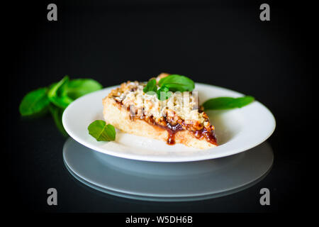 Süße Kuchen mit Früchten Marmelade in eine Platte auf schwarzem Hintergrund Stockfoto