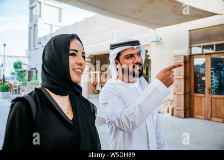 Glückliches Paar die Zeit in Dubai. Mann und Frau in traditioneller Kleidung, Einkaufen in der Altstadt Stockfoto