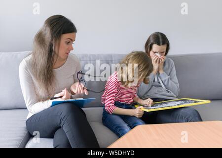 Kind professionellen Psychologen arbeiten mit Familie, zwei Schwestern im Büro. Psychische Gesundheit von Kindern Stockfoto