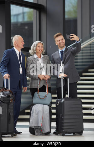 Lächelnden jungen business forum Lautsprecher mit Stoppeln unter selfie mit Kollegen in Flughafen Stockfoto