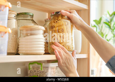 Lebensmittel in der Küche Zutaten speichern in die Speisekammer. Frau unter Glas Pasta Stockfoto