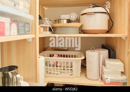 Holzregale mit Essen und Geschirr, Küchengeräte in der Speisekammer. Stockfoto