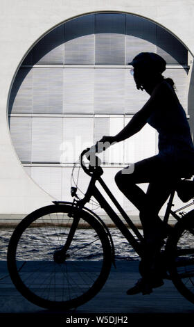 Berlin, Deutschland. 28. Juli 2019. Eine Frau Radfahrer Fahrten durch das Regierungsviertel am Ufer der Spree im hellen Sonnenschein. Quelle: Jörg Carstensen/dpa/Alamy leben Nachrichten Stockfoto