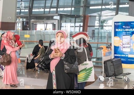 Indonesische muslimische Frauen mit Kopftuch in Soekarno - Hatta International Airport Terminal 3 Flüge Check-in-Bereich. Jakarta, Indonesien Stockfoto