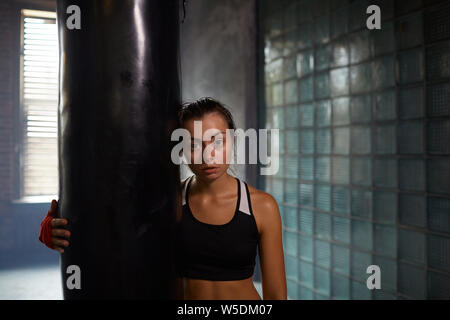 Candid Taille bis Portrait von harten Kämpferin mit Boxsack boxing Praxis aufwerfen, kopieren Raum Stockfoto