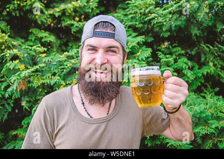 Entspannen Sie mit einem erfrischenden Getränk im Sommer. Hipster genießen Sie Bier trinken auf die Natur. Bärtiger Mann trinken alkoholische Getränk. Versuchen neue pint Power Drink. Stockfoto