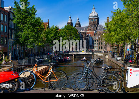 Fahrräder, die auf der Brücke, die den Kanal in Amsterdam, Niederlande, Kreuze Stockfoto
