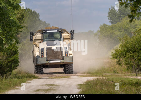 Bau-Dump Truck Rennen, unbefestigte Straße in einem bewaldeten Gebiet. Stockfoto