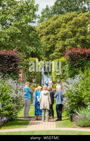 Die Menschen genießen den Tag in der National Trust Eigentum von Hidcote Manor Gardens mit ihren krautigen Blumenrabatten in den englischen Cotswolds Stockfoto