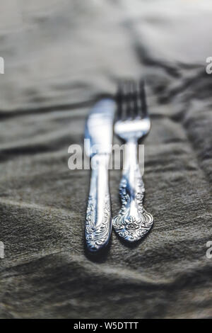 Retro Vintage Besteck Messer und Gabel auf antiken Tischdecke. Stockfoto