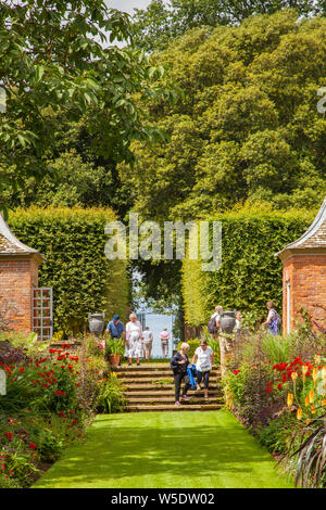 Die Menschen genießen den Tag in der National Trust Eigentum von Hidcote Manor Gardens mit ihren krautigen Blumenrabatten in den englischen Cotswolds Stockfoto