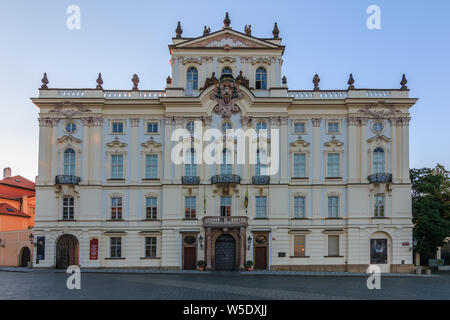 Erzbischöfliche Palast in der Nähe der Einfahrt zum Prager Burg auf dem Hradschin entfernt. Historisches weißes Gebäude mit Dekorationen in der Abendsonne Stockfoto