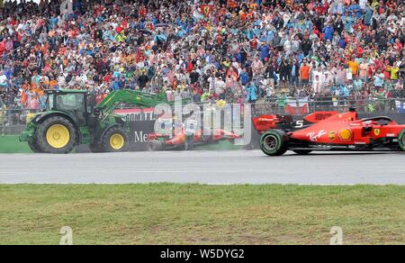 Hockenheim, Deutschland. 28. Juli 2019. firo: 28.07.2019, Motorsport, Formel 1, Saison 2019/2020, Grand Prix von Deutschland, Hockenheim Rennen, Charles Leclerc, Scuderia Ferrari, Fahrten im Reifenstapel, Gang, Unfall, Sebastian Vettel, Scuderia Ferrari, vorbei, | Nutzung der weltweiten Kredit: dpa/Alamy leben Nachrichten Stockfoto