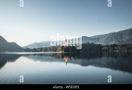 Schöne bunte Sonnenaufgang über einem alpinen See Bled in Slowenien mit der Kirche im Hintergrund Stockfoto