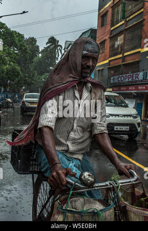 Kolkata, Indien. 28. Juli 2019. Ein Radfahrer fährt bei schwerem Regen in Kalkutta, Indien, am 28. Juli 2019. Indien ist derzeit in der Monsunzeit, die bis September dauern. Credit: tumpa Mondal/Xinhua/Alamy leben Nachrichten Stockfoto