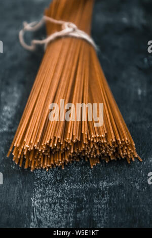 Raw vollkorn Spaghetti in einem Brötchen auf einem dunklen Hintergrund. Blick von oben. Stockfoto