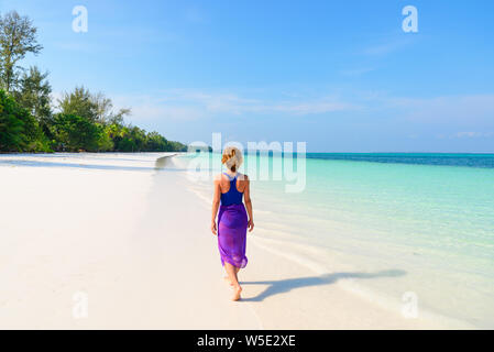 Frau Wandern am tropischen Strand. Ansicht der Rückseite White Sand Beach türkis durchsichtig Wasser Karibik reale Menschen. Indonesien Kei Inseln Molukken trave Stockfoto