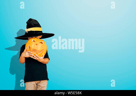 Halloween 2019 Ferienwohnung Konzept. Süße kleine Zicklein mit geschnitzten Kürbis. Happy little boy Holding ein großes Halloween Kürbis. Kopieren Sie Platz für Text Stockfoto