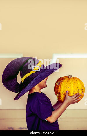 Halloween 2019. Little boy Holding geschnitzten Halloween Kürbis - Jack O'Lanterns im Außenbereich. Familie Vorbereitungen für Halloween Urlaub. Stockfoto