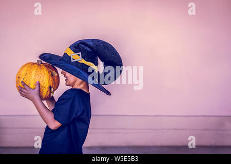 Halloween 2019. Little boy Holding geschnitzten Halloween Kürbis - Jack O'Lanterns im Außenbereich. Familie Vorbereitungen für Halloween Urlaub. Stockfoto