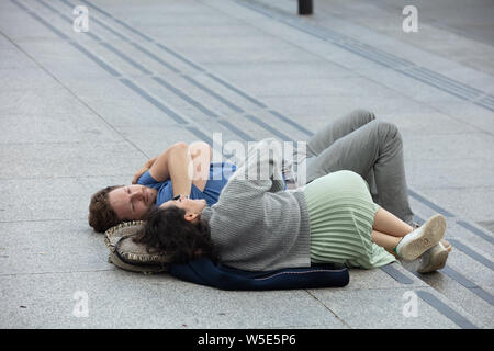 Junges Paar entspannende und Festlegung auf die Schritte der Trafalgar Square in London an einem warmen Tag im Juni. Stockfoto