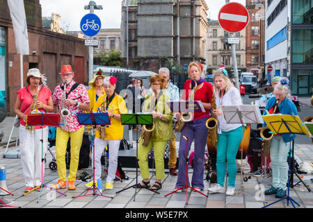 Glasgow, Schottland, Großbritannien. 28. Juli 2019. Musiker aus der Band Straatorkest Eigen Hulp aus Den Haag, Niederlande Während der Merchant City Festival. Feiert es im dritten Jahr, das encontro Street Band Festival ist eine Koproduktion zwischen Oi Musica und SambaYaBamba und umfasst alle Arten von street Drumming, Karneval Messing, New Orleans Marching Band, Afro-brasilianische Percussion, gerade nach oben, Samba und vieles mehr. Credit: Skully/Alamy leben Nachrichten Stockfoto