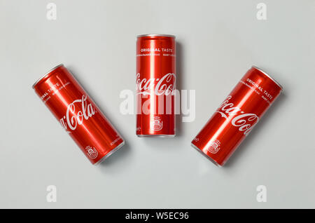 Charkow, Ukraine - 15. JULI 2019: Flach Schuß für kohlensäurehaltige Softdrinks Dosen Coca Cola Festlegung auf blauem Hintergrund. Trinken wird produziert und hergestellt Stockfoto