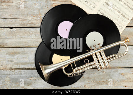 Alte Trompete- und Schallplatten auf Holzhintergrund. Stockfoto