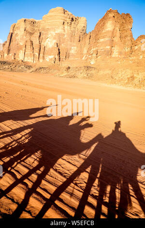 Schatten Silhouette von Reitern auf Kamelen in die Wüste des Wadi Rum, Jordanien. Stockfoto