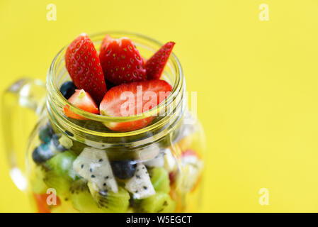 Fruchtsalat im Glas frischen Sommer Obst und Gemüse gesunde Bio-lebensmittel Erdbeeren, Kiwi Blaubeeren Dragon Fruit tropical Tomate pineappl Stockfoto
