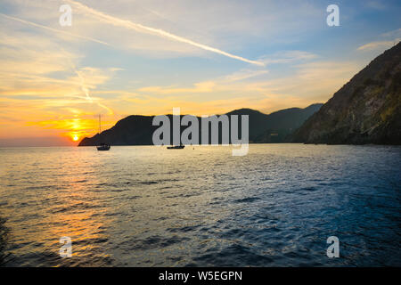 Zwei Boote im Hafen Bucht von Vernazza Italien Cinque Terre wie die Sonne an der ligurischen Küste von Italien setzt. Stockfoto