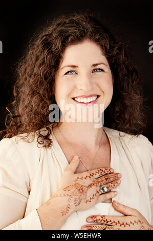 Gerne moderne geistliche Frauen mit Mehndi auf ihre Hände zu halten, zu Ihrem Herzen. Stockfoto