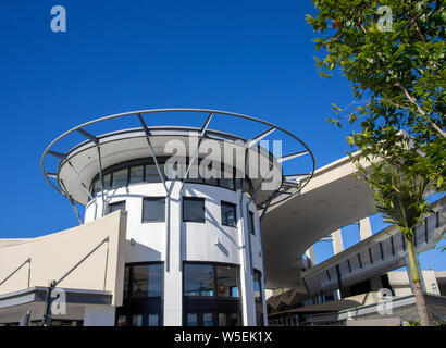 Rundes, modernes Gebäude und Dächer gegen den blauen Himmel Stockfoto