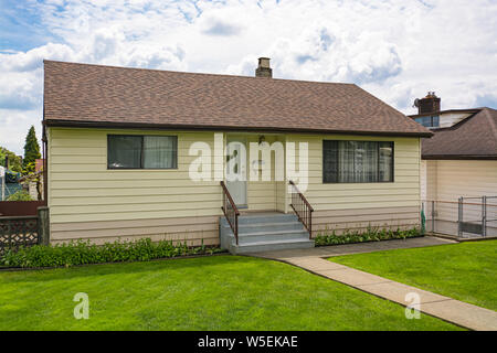 Bescheidene Haus mit grünem Rasen vor. Altes Wohnhaus Stockfoto