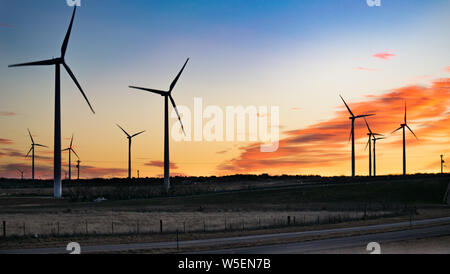 Windmühlen bei Sonnenuntergang in West Texas USA - Saubere Energie Stockfoto