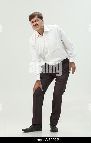 Geschäftsmann, leiden unter Schmerzen im Knie Stockfoto