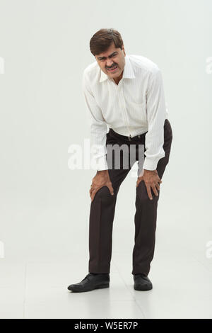 Geschäftsmann, leiden unter Schmerzen im Knie Stockfoto