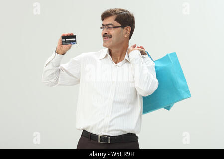 Geschäftsmann, Einkaufstaschen und Kredit Karte zeigen Stockfoto