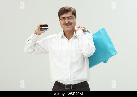 Geschäftsmann, Einkaufstaschen und Kredit Karte zeigen Stockfoto